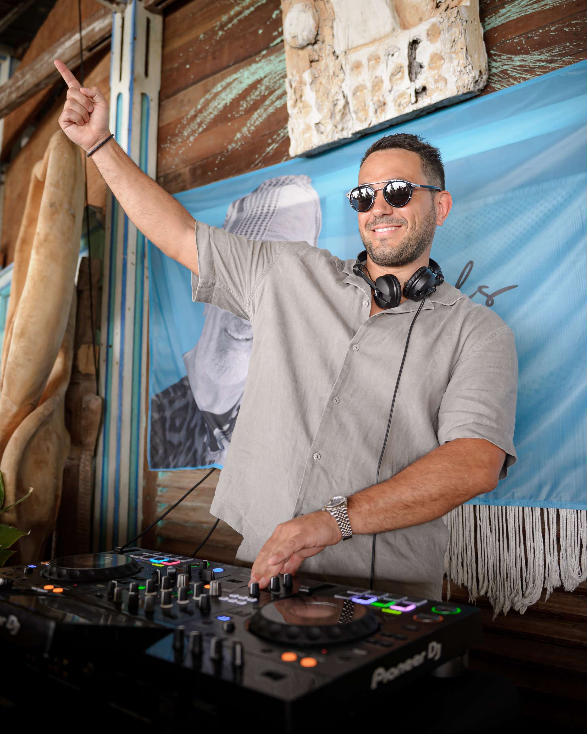 DJ à Anjuna Beach Monaco bras levé pendant un set festif en plein après-midi